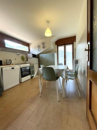 a kitchen with a dining room table and a table and chairs at Appartamento Ai Rododendri in Pray