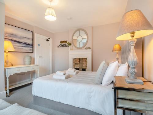 a bedroom with a large white bed and a desk at Abbey Barn Farmhouse in Marham