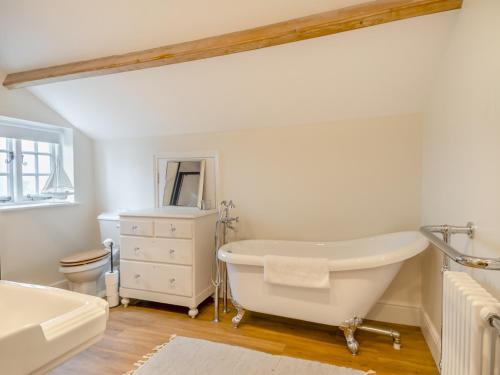 a bathroom with a tub and a toilet and a sink at Abbey Barn Farmhouse in Marham