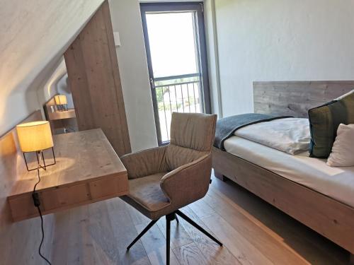 a bedroom with a bed and a desk and a chair at Neues stilvolles Ferienhaus Südsteiermark in ruhiger Lage top Aussicht inkl Wallbox in Eibiswald