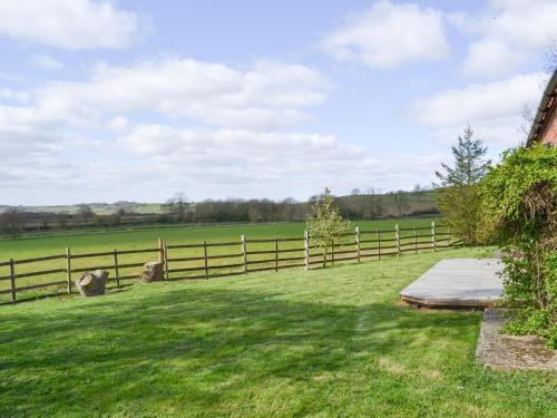 a fence in a field next to a grass yard at The Shepherds Bothy in Tetford