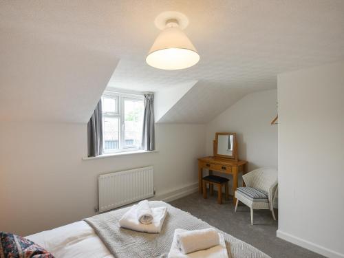 a bedroom with a bed and a window and a chair at Dolwen Isaf in Llangadfan