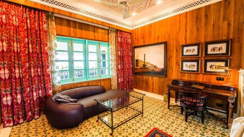 a living room with a couch and a piano at Mayfair Manor Jungpana in Darjeeling