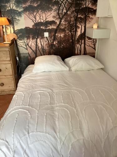 - un lit blanc dans une chambre ornée d'une peinture murale dans l'établissement Le mazet cosy, à Saint-Tropez