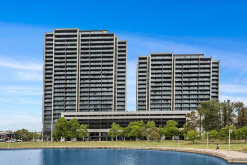 two tall buildings with a pond in front of them at Stunning Lake-View in Belconnen in Belconnen