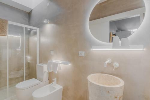 a bathroom with a toilet and a sink and a mirror at Villetta Bianca in Fontanelle