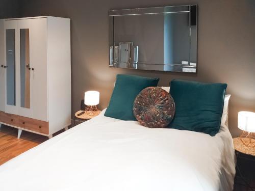 a bedroom with a large white bed with green pillows at The Inn And Around in Kenton