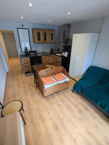 une cuisine avec une pièce avec une table et un lit dans l'établissement Studio au rez-de-chaussée accès direct jardin, à Corrençon-en-Vercors