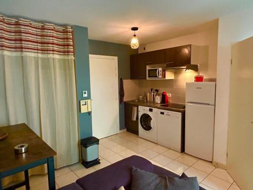 - une cuisine avec lave-linge et sèche-linge dans la chambre dans l'établissement Joli T2 niché dans les arbres au cœur du bassin, à Audenge