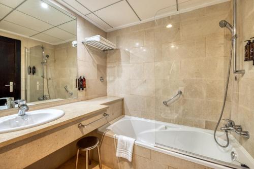 a bathroom with a tub and a sink at Senator Águilas in Águilas