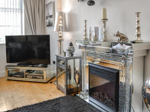 Una sala de estar con chimenea y televisión. en Apartment 2, en Bridlington