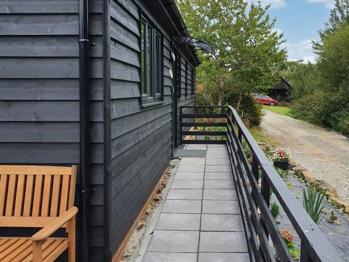 a house with a wooden bench next to a building at Rose Lodge - Uk40019 in Halwill