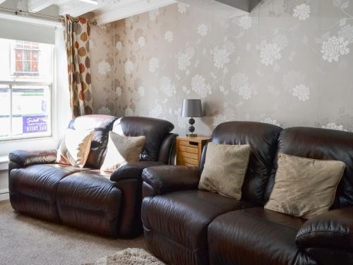 a living room with two leather couches and a couch at Ashlors in Bridlington