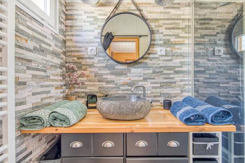 a bathroom with a sink and a mirror and towels at La Gascogne in Andernos-les-Bains