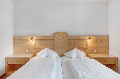 two beds sitting next to each other in a bedroom at Residence Nussbaumer in Siusi