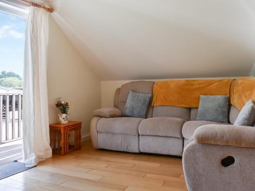 a living room with a couch and a window at Lavrean Farm in St Austell