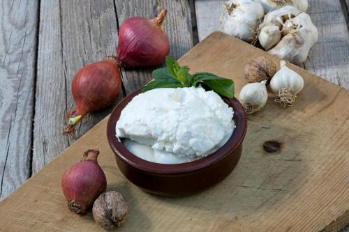 a bowl of white cheese on a cutting board with garlic at Örsmaris Boutique Hotel in Marmaris