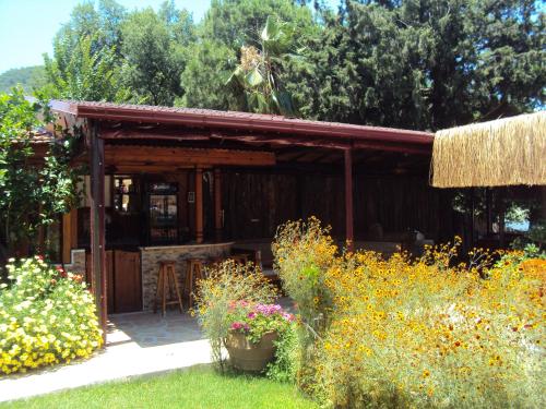 a wooden cabin with a table and some flowers at Dalyan Pension in Dalyan