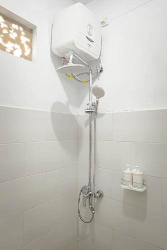 a shower in a bathroom with a shower head at Mesari Cottage Guest House in Buleleng