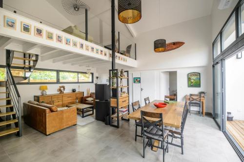 une salle à manger et un salon avec une mezzanine dans l'établissement Superb villa with terrace and pool near the Ocean, à Moliets-et-Maa