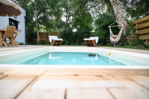 - une piscine avec des chaises et un hamac dans l'arrière-cour dans l'établissement Superb villa with terrace and pool near the Ocean, à Moliets-et-Maa