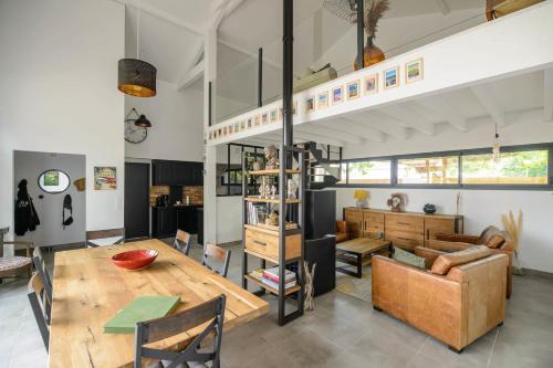 une salle à manger et un salon avec une table et des chaises dans l'établissement Superb villa with terrace and pool near the Ocean, à Moliets-et-Maa