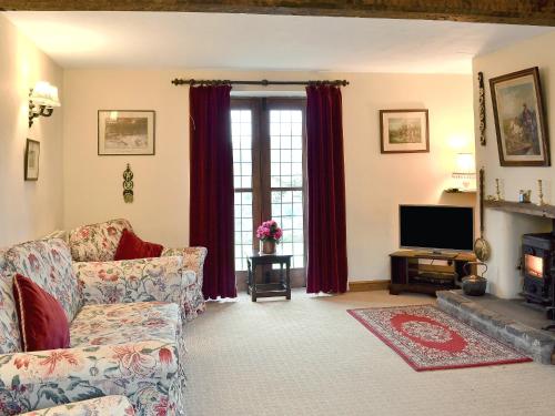 a living room with a couch and a television at Townfield Farm in Chinley