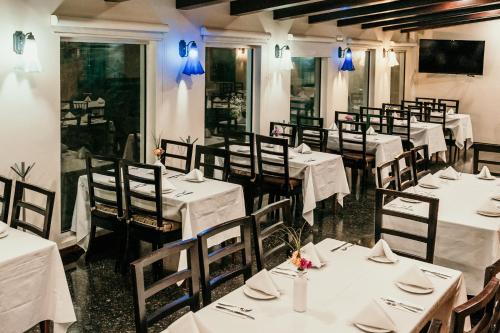 a dining room with white tables and chairs at Holiday Inn Durango by IHG in Durango