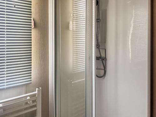 a bathroom with a white door and a window at Oaks in Porthcawl