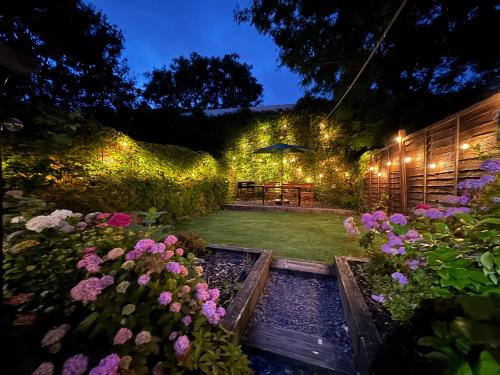 a garden at night with a table and flowers at City Centre Victorian Terrace in Cardiff