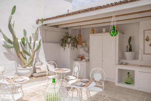 een woonkamer met witte stoelen en tafels bij Palmieri Luxury Rooms in Gallipoli