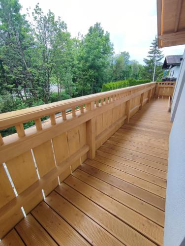 a wooden balcony with a view of trees at Sonnrain GmbH Apartment Sonnberg 77 Leogang in Leogang