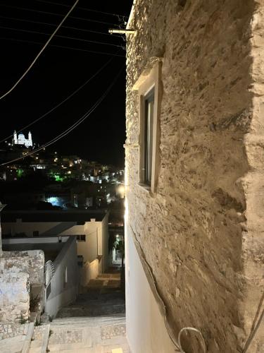a window on the side of a building at night at Nymfea Ano Syros in Ano Syros