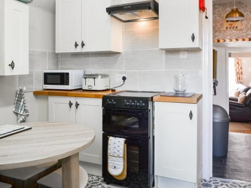 a kitchen with a black oven and a table at Ashlors in Bridlington