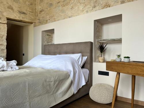 a bedroom with a large bed and a wooden table at Nymfea Ano Syros in Ano Syros