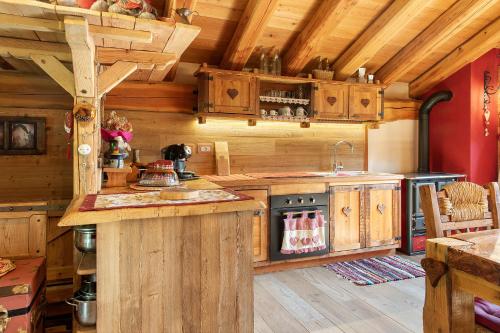 a kitchen with wooden cabinets and a counter in a cabin at Chalet Cuore Selvatico in Monno