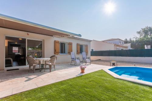 un patio avec une table et des chaises et une piscine dans l'établissement Villa les coteaux du soleil, à Carcès