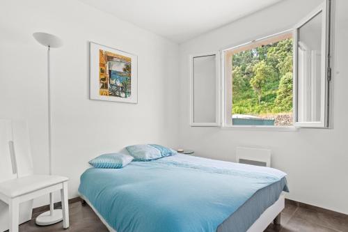 a white bedroom with a bed and a window at Villa les coteaux du soleil in Carcès