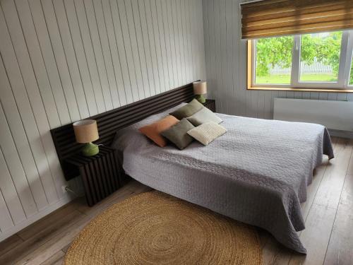 a bedroom with a bed with pillows and a window at Nicas guest house in Liepāja