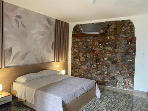 a bedroom with a bed and a brick wall at La Casa di Therry bed & breakfast in Viggiano