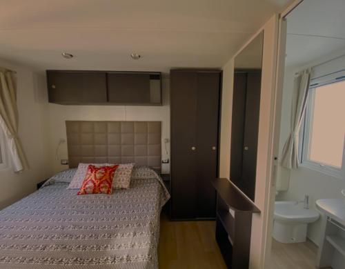 a small bedroom with a bed and a sink at Camping Torre di Barisardo in Bari Sardo