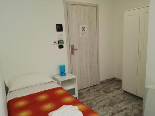 a small bedroom with a bed and a door at Hotel Paradise in Bruzolo