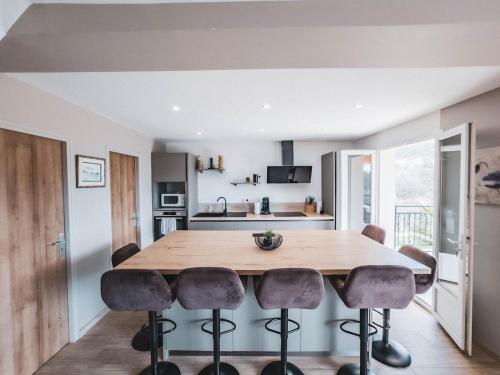 une cuisine et une salle à manger avec une table et des chaises en bois dans l'établissement Villa Roseraie, Comfort and nature, à La Celle-sous-Gouzon