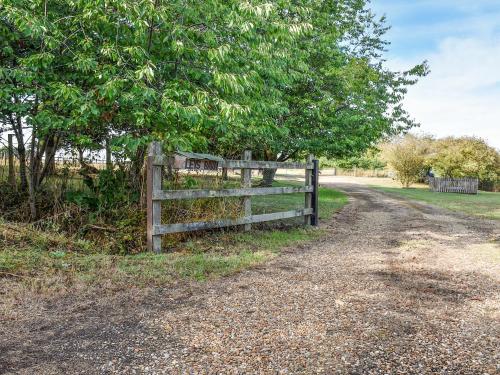 a fence on the side of a dirt road at Leys Barn in Great Chishall