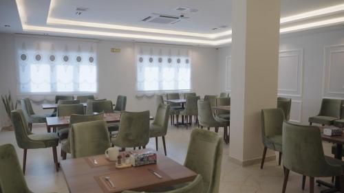 a dining room with tables and green chairs at فندق الأمراء بلازا in Ma‘ān