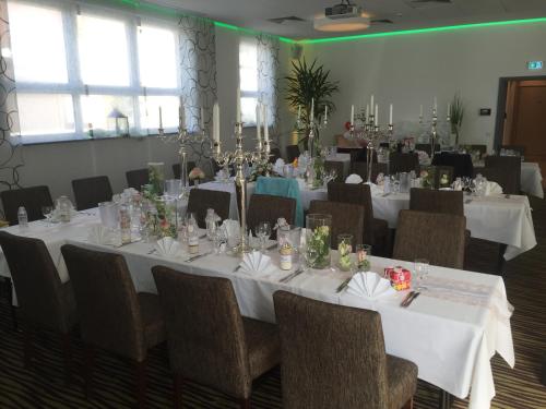 a banquet room with white tables and chairs at Hotel Sachsenross in Nörten-Hardenberg