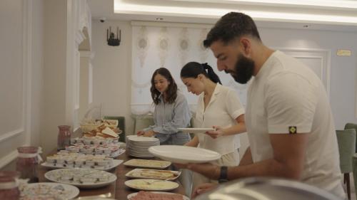 a group of people standing around a table with food at فندق الأمراء بلازا in Ma‘ān