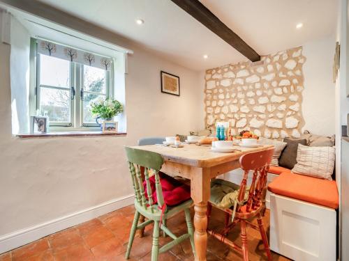 a kitchen with a wooden table and chairs at Cherry Tree Cottage - Uk30237 in Great Snoring