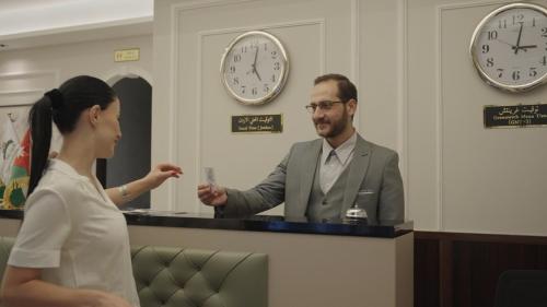 a man and a woman standing in front of a counter at فندق الأمراء بلازا in Ma‘ān