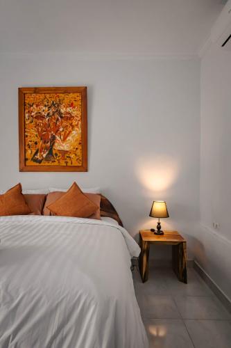 a bedroom with a bed and a table with a lamp at Mesari Cottage Guest House in Buleleng